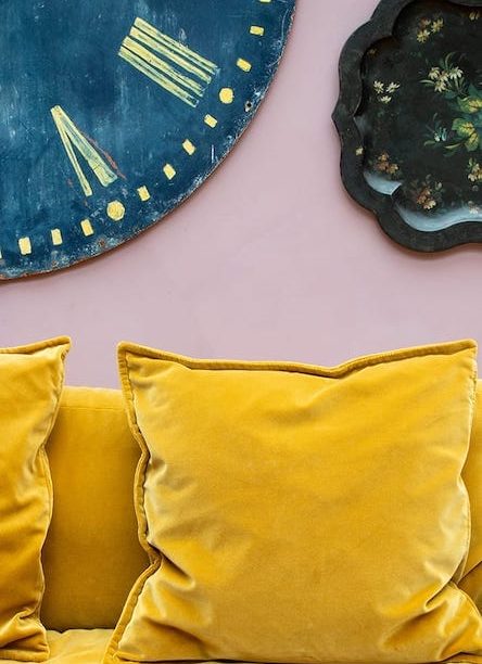 Yellow velvet pillows and blue clock