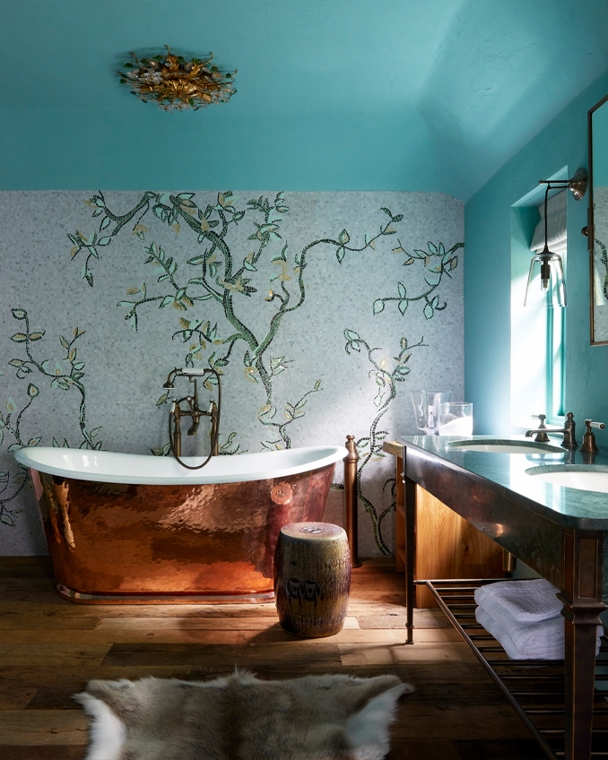 An old-fashioned roll-top bath on a wooden floor provided by Lubelska that shows how luxury bathroom ideas can come to life even in a traditional country home.