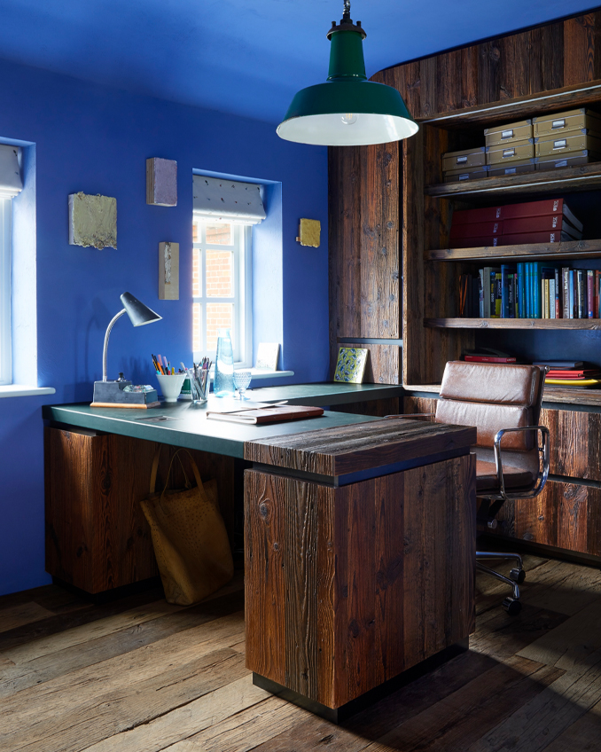 A home office design with bold blue paint made by Fidel Matt Emulsion from The Cuban Collection by Francesca’s Paints. The blue colour brings out the detail in the dark wood of the desk and shelves.