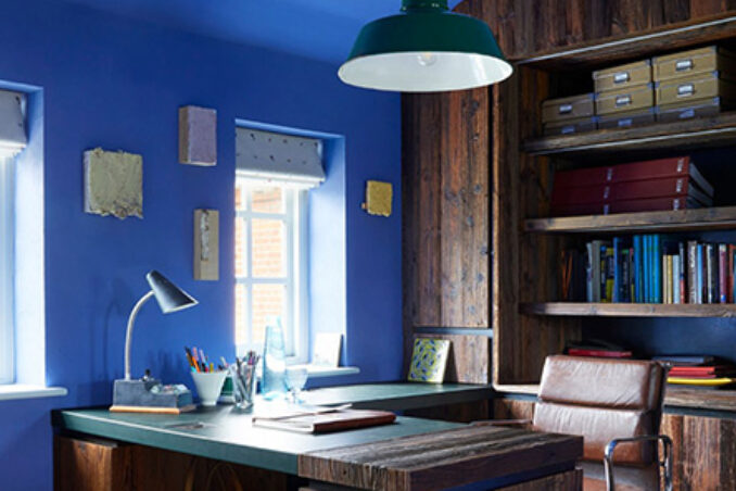 A home office design with bold blue paint made by Fidel Matt Emulsion from The Cuban Collection by Francesca’s Paints. The blue colour brings out the detail in the dark wood of the desk and shelves.